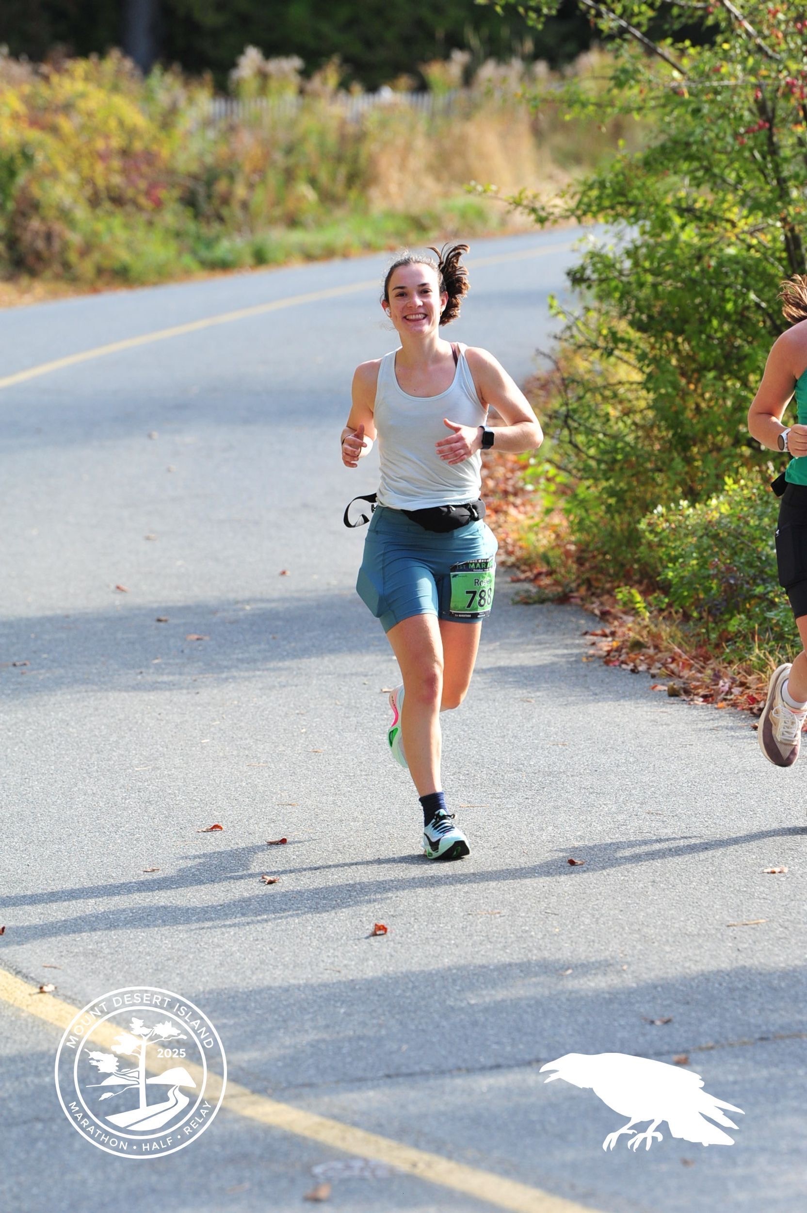 Rosie running the Mount Desert Island Marathon in Acadia National Park, smiling mid-stride.