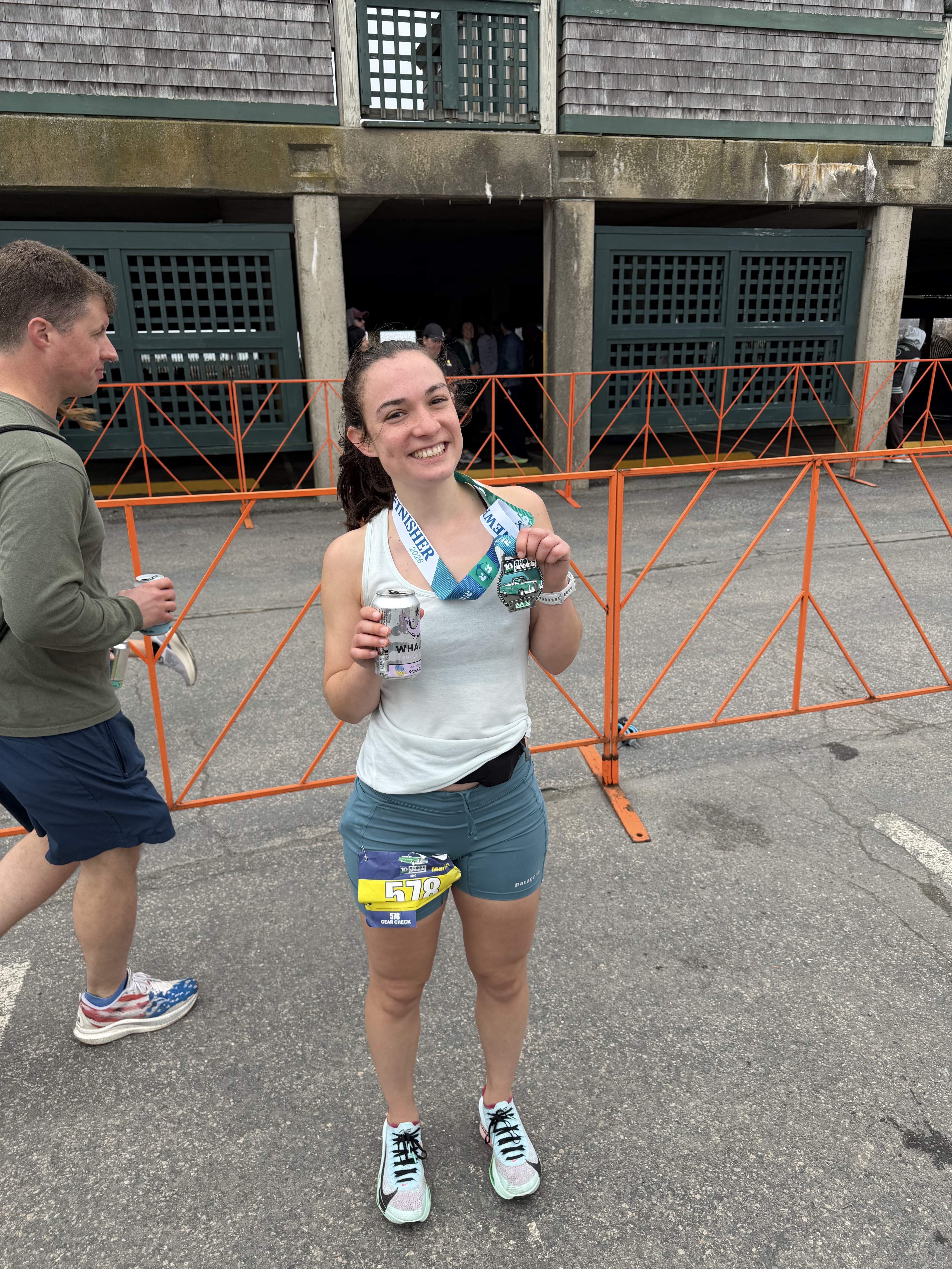 Rosie holding a finisher medal and a beer after the Newport Marathon.