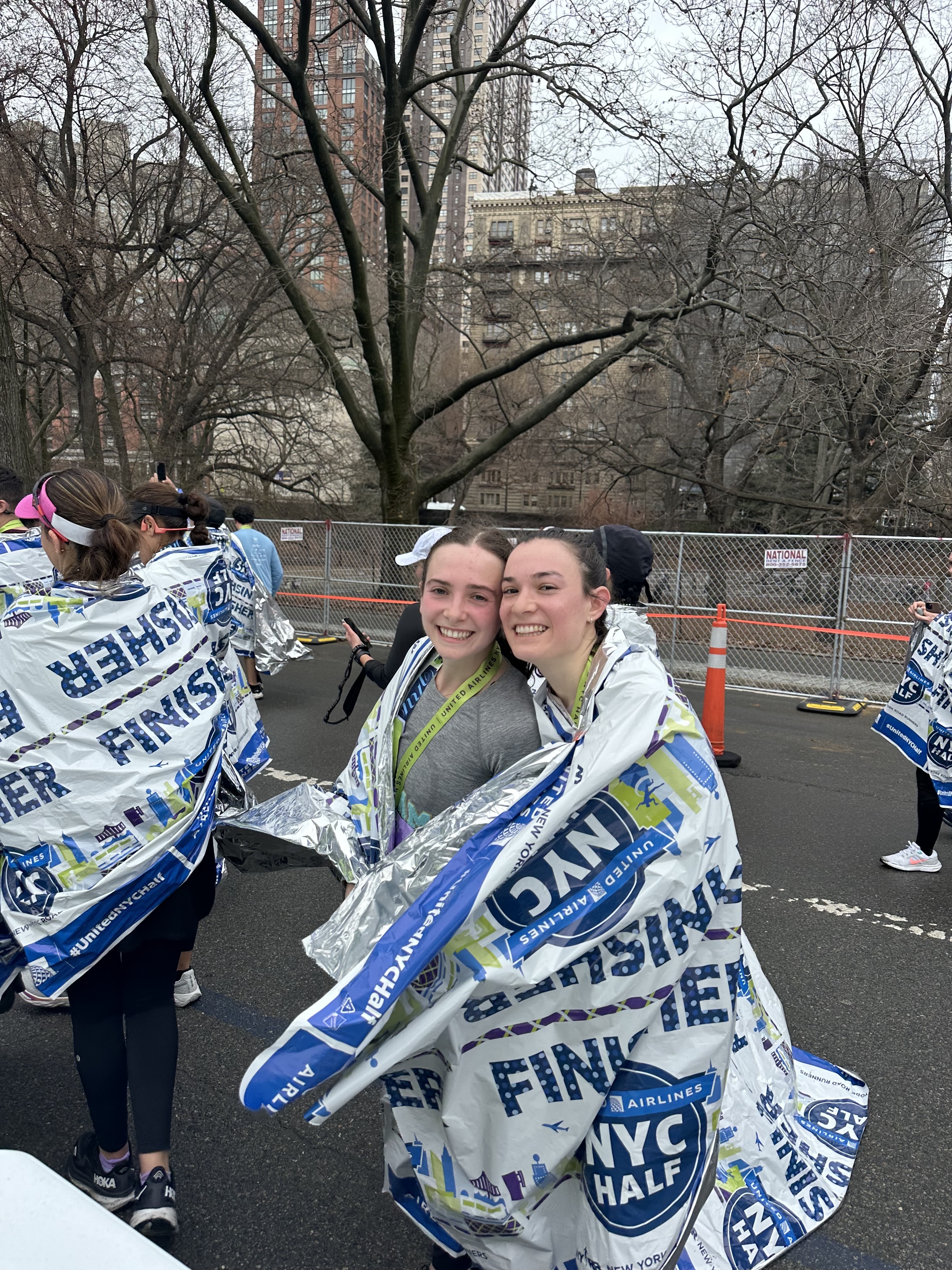 Rosie and a friend wrapped in finisher blankets after the United NYC Half.